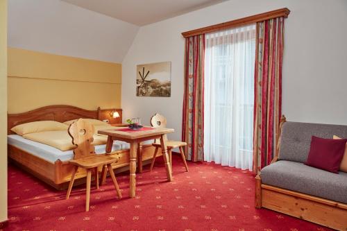 克勒希Hotel Domittner的酒店客房配有床、桌子和沙发。