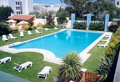 圣克莱门特雷图尤莫拉莱斯酒店的游泳池周围设有躺椅和躺椅