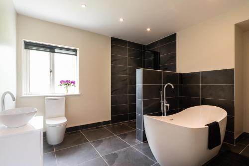 肯梅尔Bay View House的带浴缸、卫生间和盥洗盆的浴室