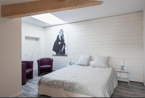 索恩河畔自由城Grand duplex au calme en centre-ville的一间卧室配有一张床和两张紫色椅子
