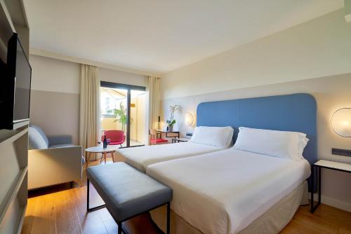 马拉加Eurostars Málaga的一间卧室配有一张大床和蓝色床头板