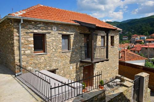 弗洛里纳Traditional Stone Villa "To Petrino"的一栋石头房子,位于一栋建筑中,设有阳台