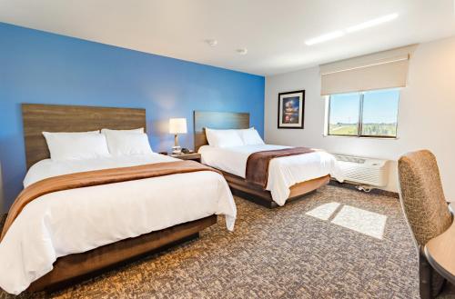 沃特敦My Place Hotel-Watertown, SD的一间卧室设有两张床和蓝色的墙壁