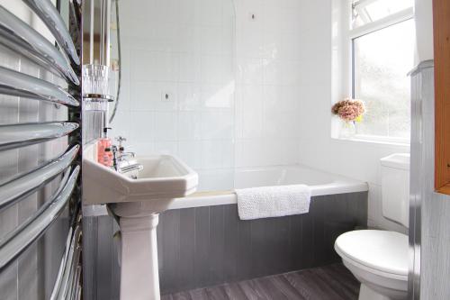 科尼斯顿Bridge End Cottage的一间带水槽、浴缸和卫生间的浴室