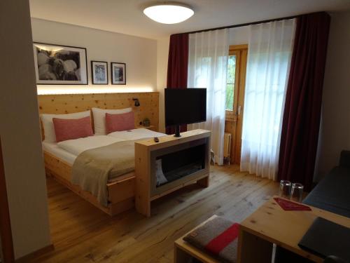 阿尔代兹斯科塔的阿尔维图酒店的一间卧室配有一张床和一张桌子上的电视