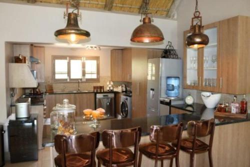 玛洛斯帕克卢维尔斯豪华别墅的厨房配有桌子和一些棕色椅子