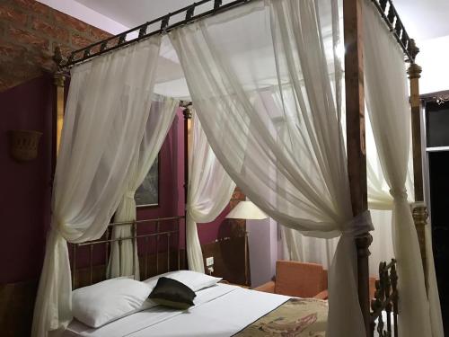 卢克索Rezeiky Hotel & Camp的卧室配有带白色窗帘的天蓬床