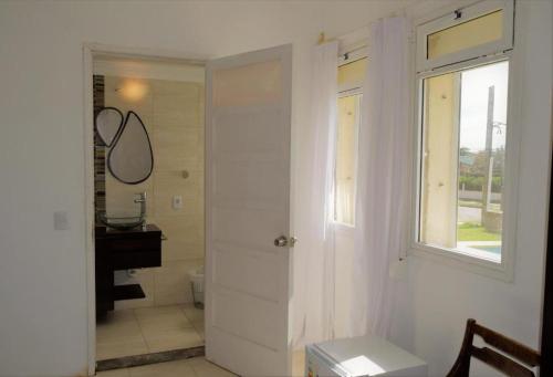 拉帕洛马Hotel Cabo Santa Maria的一间带卫生间、窗户和水槽的浴室