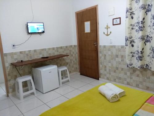 乌巴图巴Suítes Veleiro的一间设有门的房间和墙上的电视