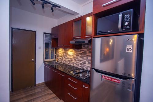 高尔Seabreeze Apartment的厨房配有不锈钢冰箱和微波炉。