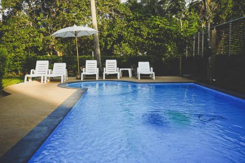 班邦宝苏梅岛内提夫斯别墅的游泳池配有椅子、遮阳伞和遮阳伞
