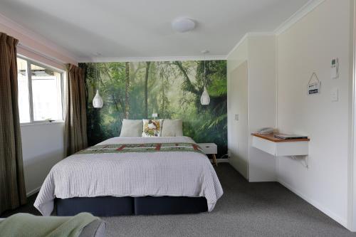 蒂阿瑙亚丁汽车旅馆的一间卧室配有一张壁画床