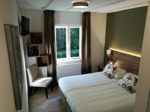 希尔登卡斯特艾森博格酒店的卧室配有床、椅子和窗户。