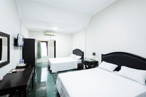 日惹加仑安妮提塔酒店的酒店客房配有两张床和一张书桌