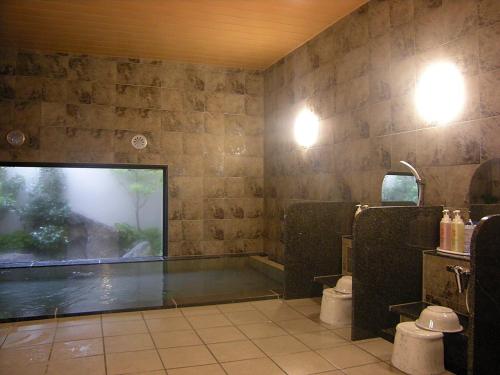 由利本庄市由利本庄路线酒店的带浴缸、卫生间和窗户的浴室