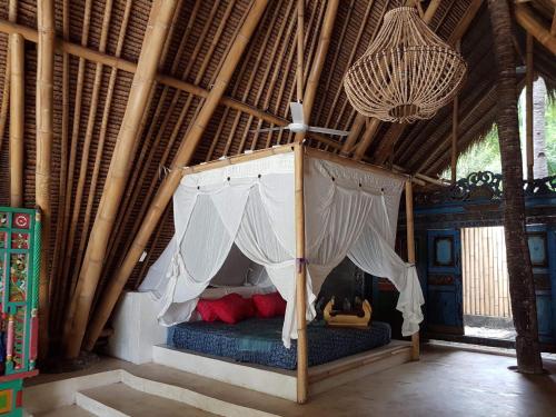 毛梅雷Eco dive resort Alycastre的小屋内一间卧室配有一张天蓬床