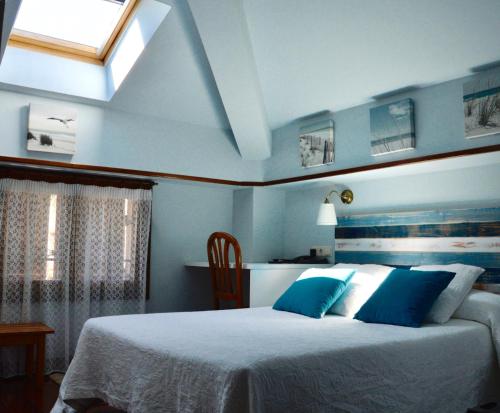 扎鲁亚斯阿拉米达酒店的一间卧室配有一张蓝色墙壁的床和一扇窗户