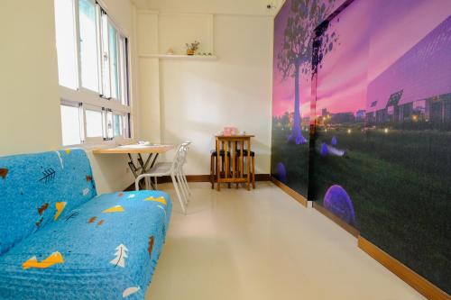 台东美泰の民宿的客厅配有蓝色的沙发和桌子