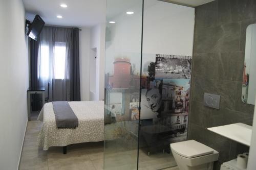 菲格拉斯Hostal Sanmar的一间带床、卫生间和淋浴的浴室