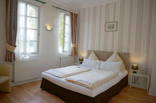 威斯巴登阿姆舒洛斯布里希酒店的一间卧室配有一张带白色床单的床和一扇窗户。