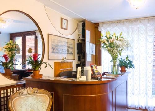 威尼斯莱奥纳多酒店的一间设有前台和镜子的等候室