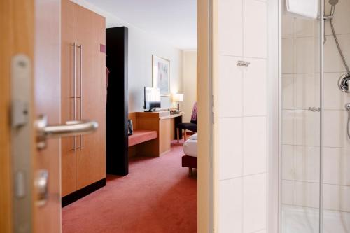 施特拉尔松德伽格菲斯汀格酒店的酒店客房设有淋浴和一间卧室。