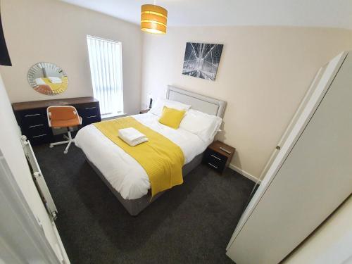 曼彻斯特Salford Holiday Apartment Manchester的一间卧室配有一张带黄色毯子的大床