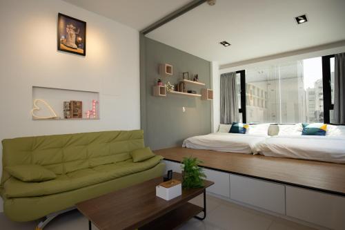 台南YouI98 Guesthouse一層一戶大坪數套房#本國旅客須先匯款的客厅配有床和沙发
