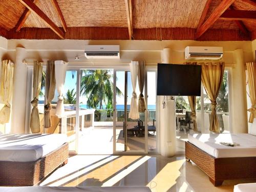 长滩岛Kaiyana Boracay Beach Resort的一间卧室配有两张床和一台平面电视