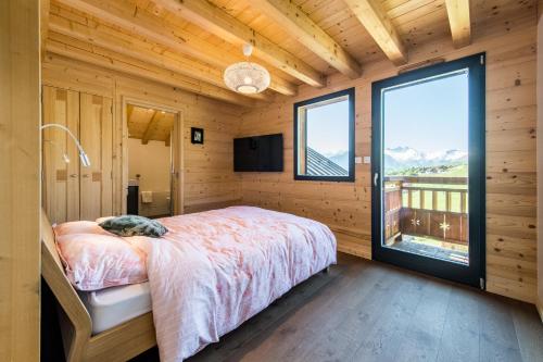 土绪尔Harfang des Neiges的一间卧室设有一张床和一个大窗户