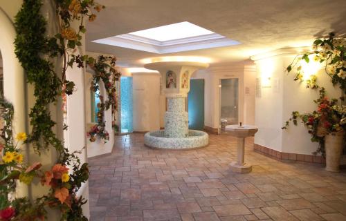 SarnonicoHotel Waldheim的花房中带喷泉的走廊