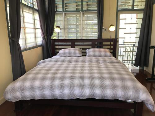 宋卡Ban Soi San Sook Homestay的窗户间内的一张带两个枕头的床