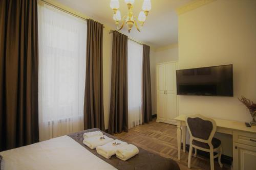 皮亚特拉-尼亚姆茨La Curtea Domneasca的酒店客房配有一张床、一张书桌和一台电视。