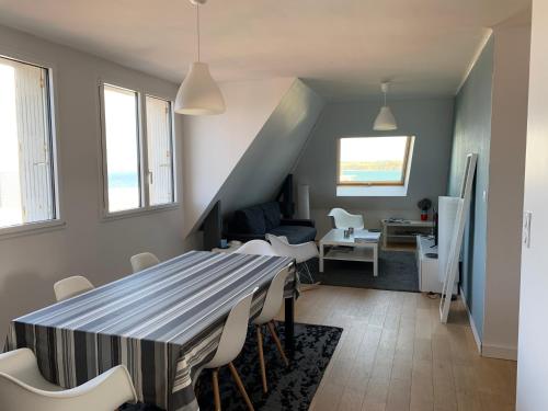 杜瓦讷内Appartement Design II - Port du Rosmeur -Douarnenez的用餐室以及带桌椅的起居室。