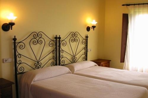 LamuñoApartamentos Rurales La Regatina的一间卧室配有两张带白色床单的床