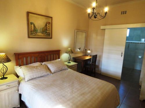 干斯拜Gansbaai Central Accommodation的一间卧室配有一张床、一张桌子和一张书桌