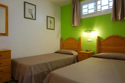 英格兰海滩厄瓜多尔公寓的一间卧室设有两张床和绿色的墙壁