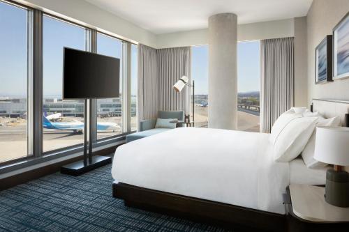 米尔布雷Grand Hyatt at SFO的一间酒店客房,设有一张大床和一个大窗户