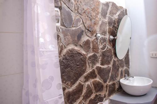 CuispesYUMBILLA ECO LODGE的一间带水槽和石墙的浴室