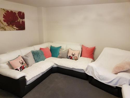 利物浦Liverpool Anfield的白色的沙发上配有色彩缤纷的枕头