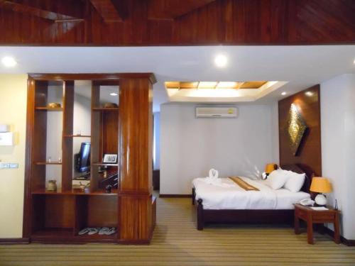 Ban Chéng查姆因劳酒店的一间卧室配有一张床和一台电视