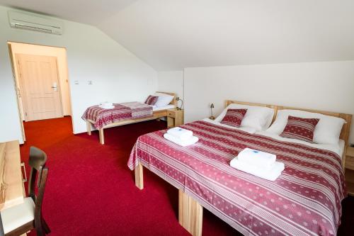 JavorniceVenclův statek的一间卧室配有两张床,铺有红地毯