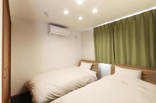 富士吉田市Villas Fujiyoshida的一间卧室设有两张床和窗户。