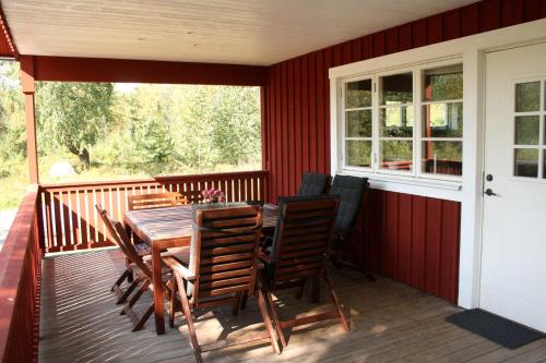 TivedGrönelid Gård的甲板上配有木桌和椅子