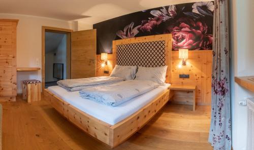 菲根SpieljochLodge的一间卧室配有一张带木制床头板的床