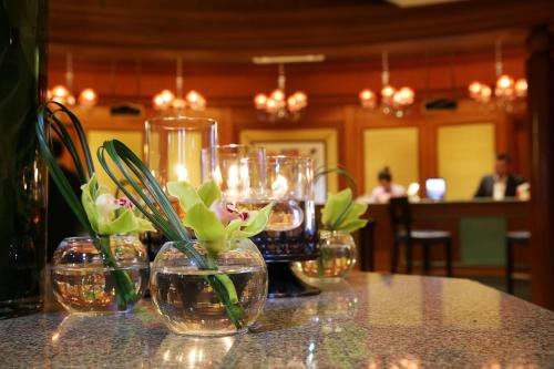 香港铜锣湾利景酒店的一张桌子,上面有三个花瓶,里面装有鲜花