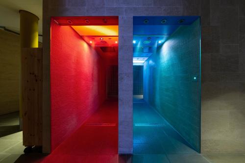 诺伊鲁平Resort Mark Brandenburg & Fontane Therme的走廊里,有红色和蓝色的灯光