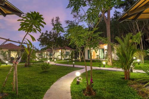 奥南海滩Aonang Eco Villa - SHA Extra Plus的夜间穿过花园的走道