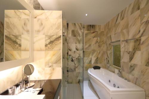 波德申宾客Spa酒店的带浴缸和盥洗盆的浴室