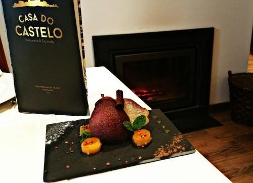 欧伦Casa do Castelo Ourém的一张桌子上带石榴的盘子,上面有书
